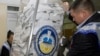 Members of a local election commission empty a ballot box at the end of the voting day on October 10.