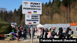 Українські біженці в час масового вторгнення Росії до України прибувають до пункту прийому на прикордонному пункті пропуску в Кросценко