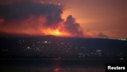 A view shows smoke and fire on the Lebanese side of the border with Israel, as seen from Tyre, southern Lebanon, early on August 25.