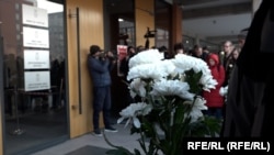 Students hold white flowers at a court building in Belgrade ahead of the sentencing of the parents of a boy who killed 9 students and security guard in a school shooting in 2023.
