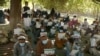 Afghans wait to receive cash distributed through an aid program in the Pachiragam Khogyani district of Nangarhar Province. (file photo)