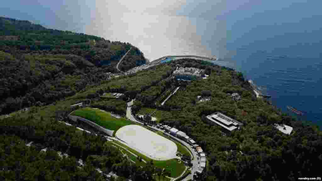 An aerial view shows the alleged hockey rink (bottom left) next to two helipads. The buildings on the curved road in the foreground are believed to be for the scores of construction workers who were visible in drone footage captured by Navalny's team. 