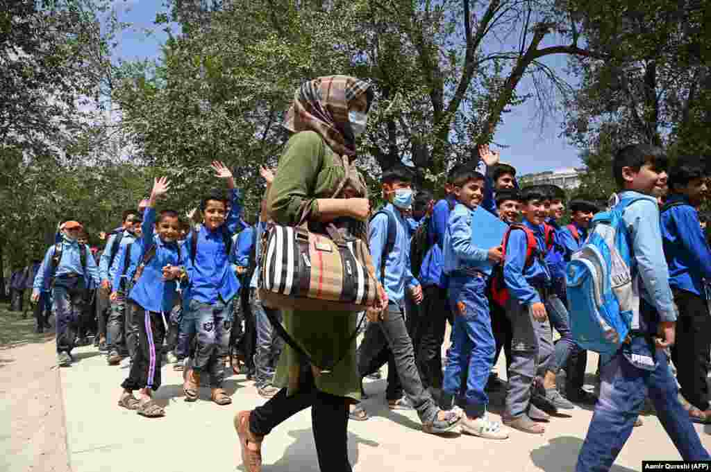 Despite the risks, some schools have reopened. These students and their teacher at a Kabul middle school were photographed on their way to class on August 30. 
