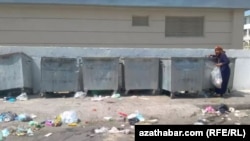 Женщина перебирает в мусорном контейнере. Ашхабад (архивное фото)