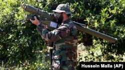  A Lebanese Hizballah fighter holds an Iranian-made antiaircraft missile on the border with Israel.