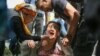 A Kazakh police officer (right) detains an opposition supporter in Almaty on June 10.