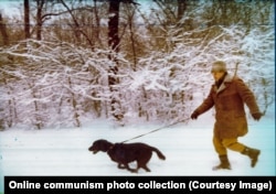 The authoritarian ruler runs with a dog at an unknown location in the winter of 1981.