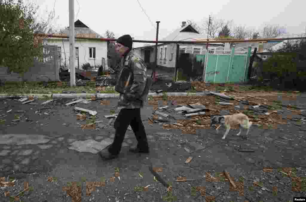 Vladimir Shramko, 48, walks past his neighbor's house, which was damaged by shelling, in the village of Spartak on the outskirts of Donetsk in October 2014.