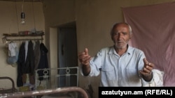 Sokrat Arakelian shows his damaged house in the village of Varhavar, which was hit by the aftershocks.