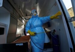 Медичний працівник використовує дезінфікувальний засіб у машині швидкої допомоги в окупованому Донецьку, 17 березня
