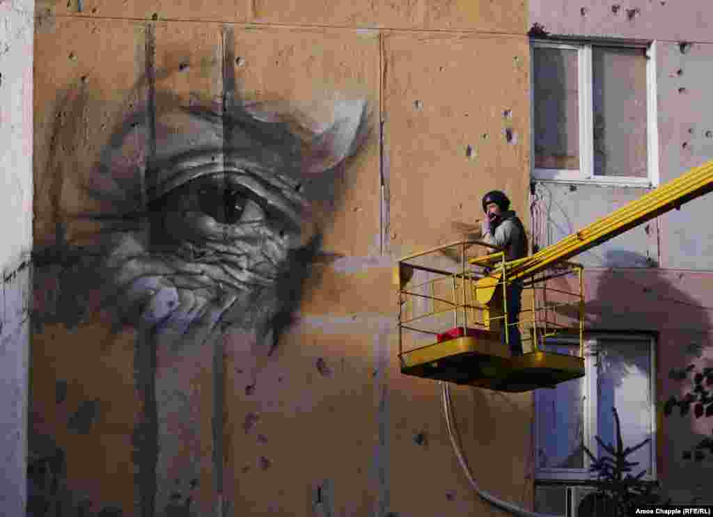 Work begins on the portrait. Van Helten says he does not intend the work to be a political statement. "Who am I to make a statement about a complex situation like this?.... Honestly though, I reckon if I went to the other side I would see just the same thing, the same kids in the classrooms.... This isn't about good and evil."