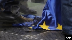 Hungarian protesters trample a burnt EU flag at a rally called by the right-wing party Jobbik in front of the EU headquarters in downtown Budapest in January 2012.