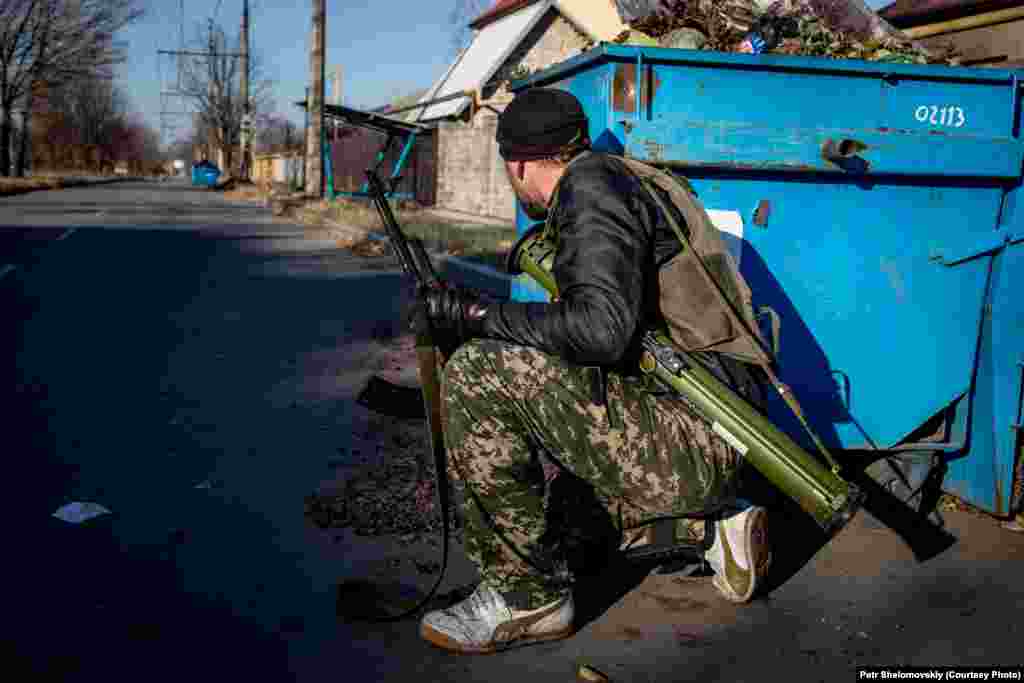 A separatist takes cover in the Kiyevskiy district of Donetsk. The district is close to the airport, which has been the scene of much of the fighting.