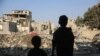 Copii se uită la distrugerile produse în urma unui atac israelian în tabăra de refugiați Nuseirat din centrul Fâșiei Gaza, la 7 noiembrie 2024, pe fondul războiului în curs dintre Israel și militanții palestinieni Hamas. (Foto: Eyad BABA / AFP)