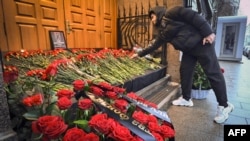 A man lays flowers to Azerbaijan's Embassy in Moscow paying tribute to the victims of an Azerbaijan Airlines' plane crash.