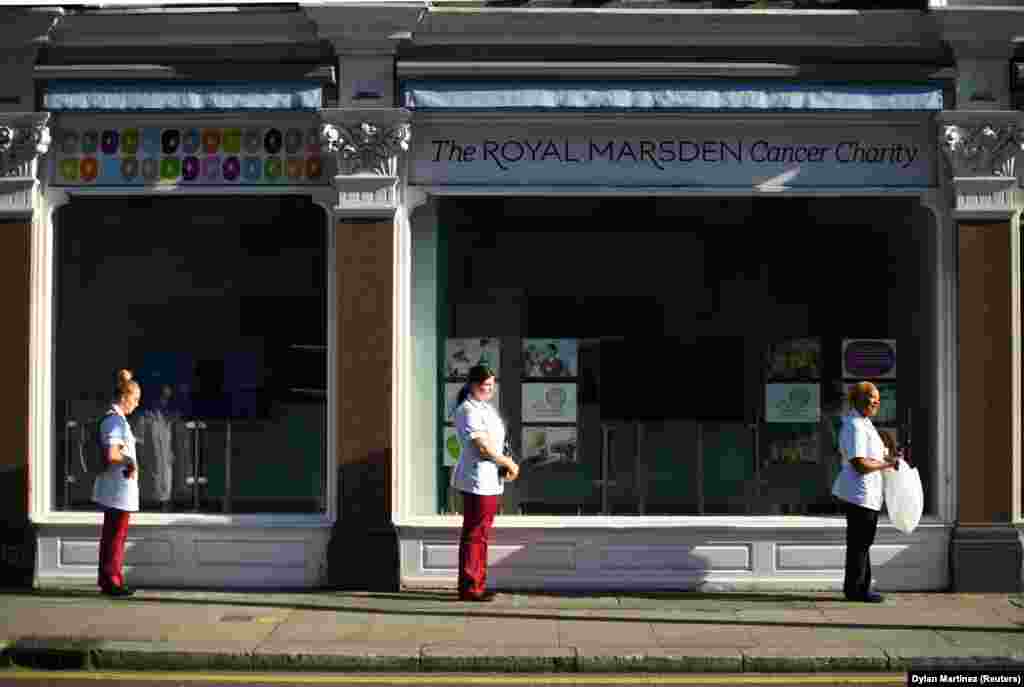 London nurses distance themselves as they line up for donated lunches on March 25. British Prime Minister Boris Johnson has implemented social-distancing measures banning social gatherings and groups of more than two people.