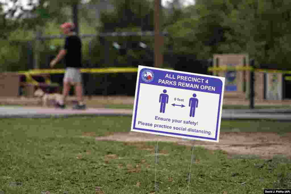 A sign is posted in a Houston park reminding people to practice social distancing. A stay-at-home order was issued on March 24 for Houston and Harris County residents to help fight the spread of COVID-19. 
