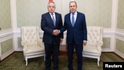 Russia's Foreign Minister Sergei Lavrov (right) shakes hands with Tajikistan's Foreign Minister Sirojiddin Muhriddin as they meet on the sidelines of a CIS conference in Minsk on April 12. 