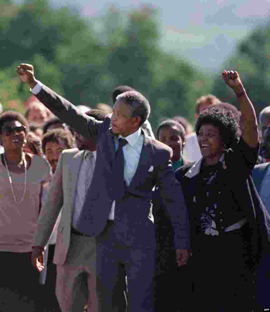 Nelson and Winnie Mandela raise their fists and salute a cheering crowd upon Nelson's release from prison after 27 years.
