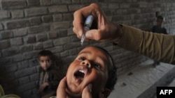 A health worker administers polio vaccine drops to a child during a vaccination campaign in Jalalabad, Afghanistan.