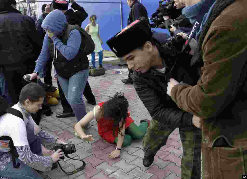 A member of Pussy Riot lies on the ground as the group are attacked by Cossack militia.