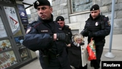 Russian police detain a protester against Russian President Vladimir Putin after she took part in a lone picket in central Moscow in April.