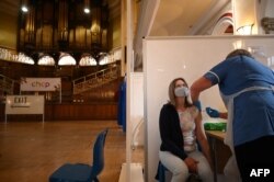O femeie din Marea Britanie primește vaccinul AstraZeneca.