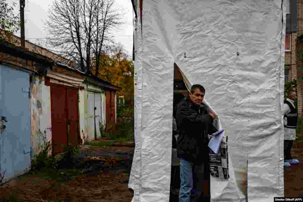 A man leaves a mobile DNA-testing laboratory in Izyum on November 4. DNA testing allows the identity of bodies to be confirmed without requiring relatives to go through the trauma of a visual identification. 