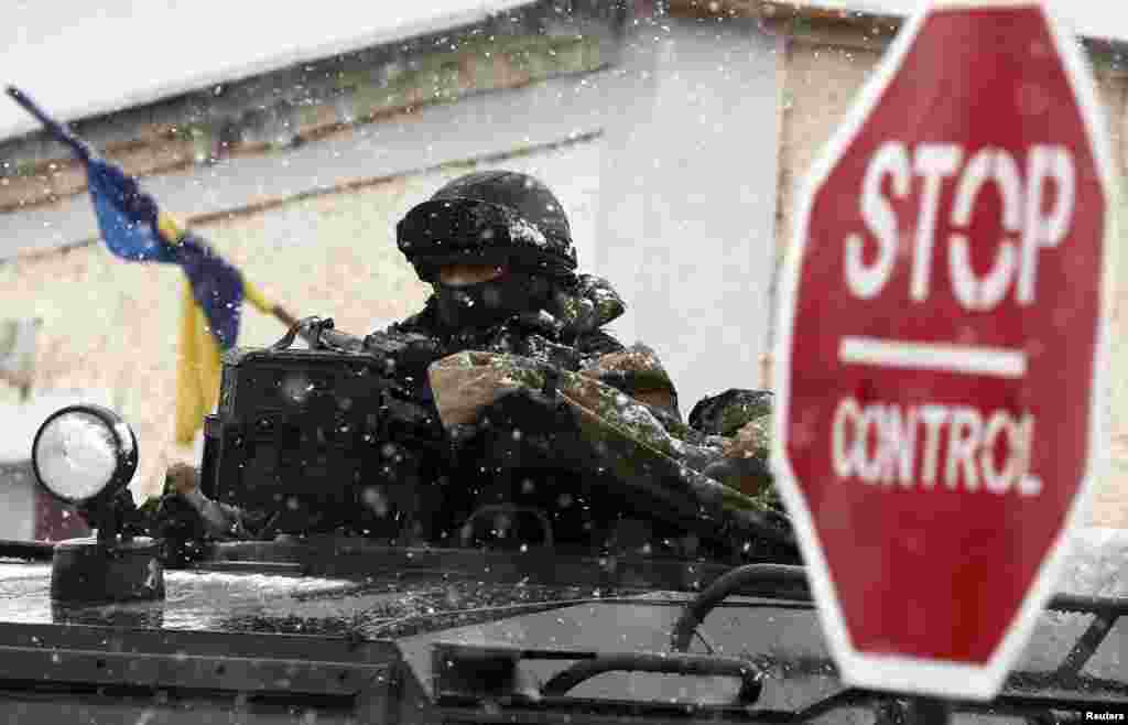 An armed man, believed to be Russian serviceman, stands guard outside a Ukrainian military base in Perevalnoye, near the Crimean city of Simferopol.