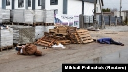 Trupurile neînsuflețite a două persoane pe o stradă din Bucea, la 60 de km de Kiev. Localnicii spun că cei doi civili au fost uciși de soldații ruși. Reuters, 3 aprilie, 2022.
