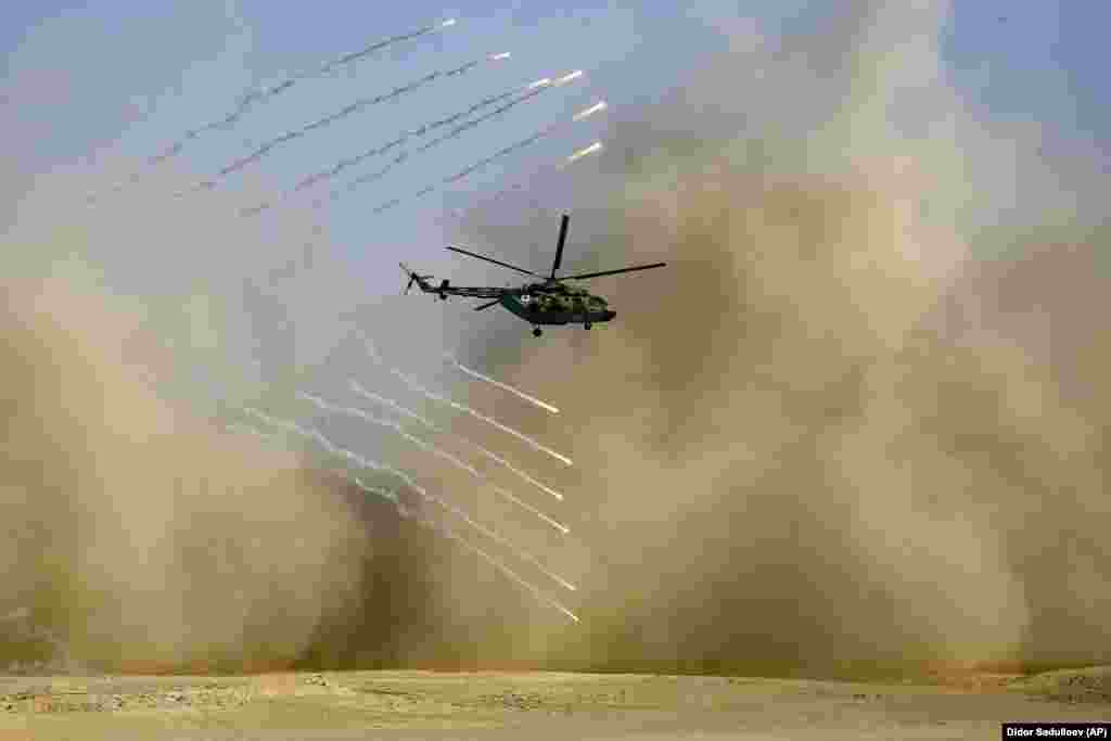 A military helicopter flies during the joint Russian, Tajik, and Uzbek drills at Tajikistan's Harb-Maidon firing range on August 10.