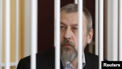 Belarusian former opposition presidential candidate Andrey Sannikau sits in a cage during a court hearing in Minsk.