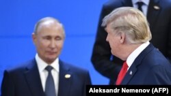 Президент США Дональд Трамп дивиться на президента Росії Володимира Путіна, коли вони займають місця для фотографування, під час саміту лідерів країн G20 в Буенос-Айресі 30 листопада 2018
