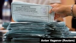 A member of a local electoral commission counts ballots at a polling station in St. Petersburg on July 1.