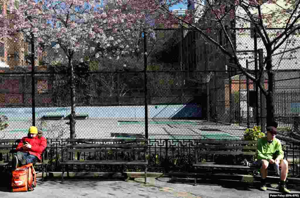 People practice social distancing while sitting in Hell's Kitchen Park in New York City on March 24.