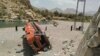 Onlookers stand next to a damaged bus at the site of an accident in a remote district of Balochistan Province. (file photo)