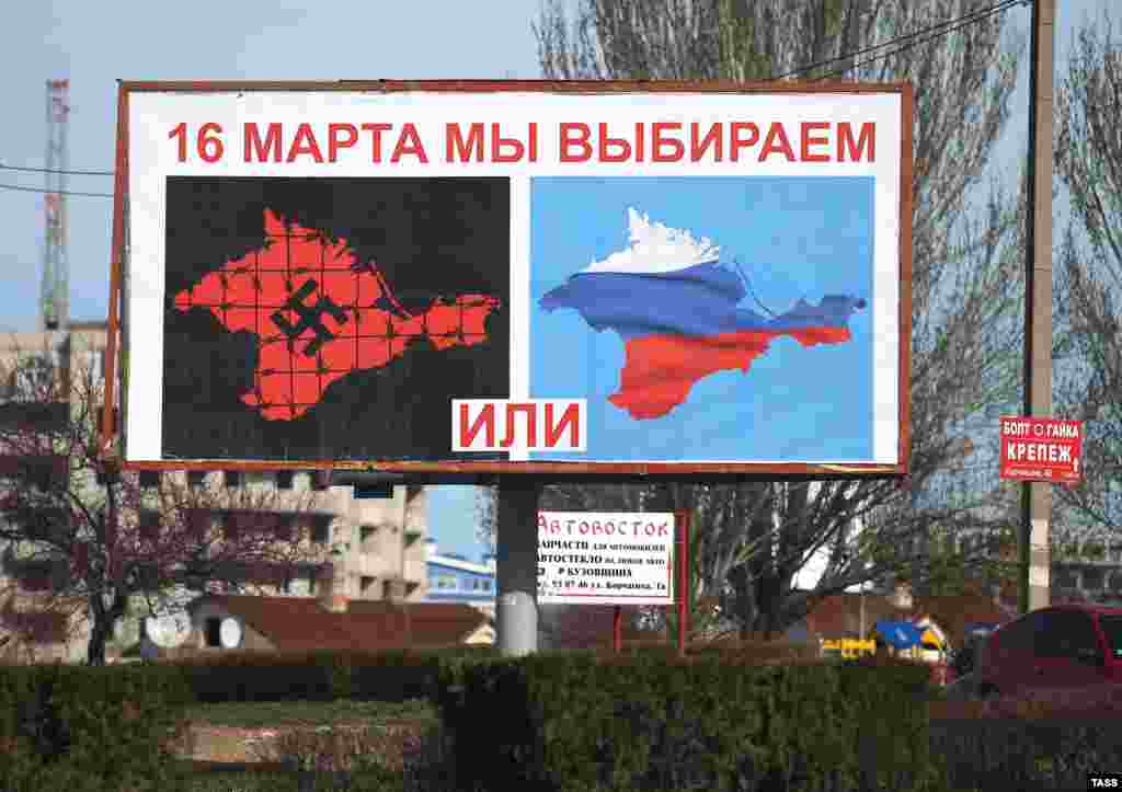 A man walks past a poster in Sevastopol on March 10 depicting a referendum called by Crimea’s pro-Russian authorities as a choice between Nazism and Russia. The March 16 referendum, which did not offer the option of Crimea retaining its status quo, was declared illegal by Kyiv and not recognized by most countries. Voters overwhelmingly opted to rejoin with Russia in a vote that was widely dismissed as falsified. 