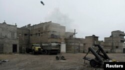 Free Syrian Army fighters fire a homemade mortar at Karm al-Tarab neighborhood in Aleppo on January 27.