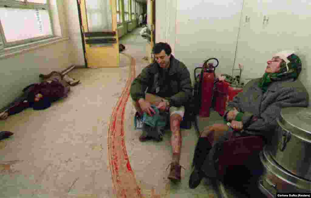 Civilians injured by a mortar in Sarajevo&#39;s central market await treatment in a hospital corridor on February 5, 1994. The woman at left died before doctors could attend to her.