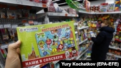A customer holds an Our Guys In Salisbury board game in a shop in Moscow.