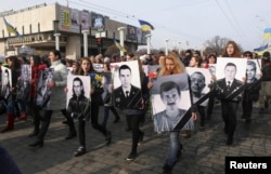 People carry portraits of local residents killed in fighting with pro-Russian separatists during a commemoration rally in Kharkiv on February 22.