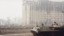 An abandoned Russian fighting vehicle stands in front of the presidential palace