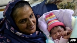 Mukhtar Mai shows off her newborn baby boy at a hospital in Multan in November 2011.
