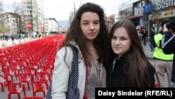 Lamia Alibegovic, 13, and Elma Ocuz, 14, visit the "Sarajevo Red Line" installment.