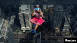 A girl observes a partial solar eclipse on the Mahanakhon Skywalk Glass Tray