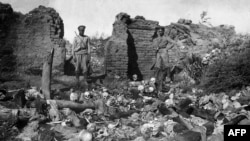 A picture released by the Armenian Genocide Museum-Institute, dated 1915, which purportedly shows soldiers standing over skulls of victims from the Armenian village of Sheyxalan in eastern Turkey during World War I.