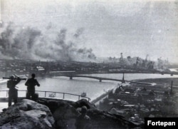 Hungarian soldiers with a range finder watch from Gellert Hill as bombs from an American air raid pummel Nazi-occupied Budapest in 1944.