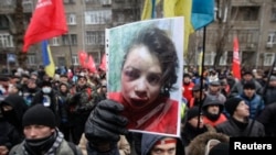 Акція протесту перед Міністерством внутрішніх справ України в Києві 25 грудня, 2013 рік. Протестувальник тримає фото журналістки Тетяни Чорновол, яку побили і залишили в канаві буквально через кілька годин після публікації статті про активи вищих державних службовців