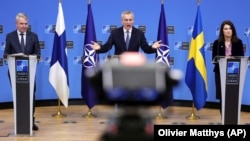 Генсекретар НАТО Єнс Столтенберґ (посередині), міністр закордонних справ Фінляндії Пекка Хаавісто (ліворуч) і міністр закордонних справ Швеції Анн Лінде (праворуч) під час спільної пресконференції у штаб-квартирі НАТО. Брюссель, 24 січня 2022 року