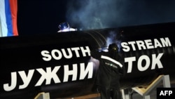 Workers weld together two giant pipes in Serbia, north of Belgrade. Brussels will expect EU-applicant Serbia to enforce its antitrust laws retroactively.